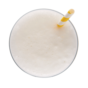 Boisson Pina Colada Ideal Protein, servie dans un verre élégant avec une touche de décoration tropicale, capturant l'essence d'un moment de détente sous les tropiques, idéale pour les amateurs de saveurs exotiques.