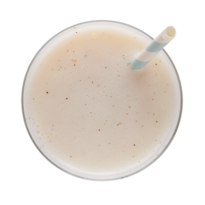 Smoothie à la vanille Ideal Protein, servi dans un grand verre transparent, surmonté d'une paille, évoquant une texture crémeuse et un goût exquis pour un boost de protéines savoureux et rafraîchissant.